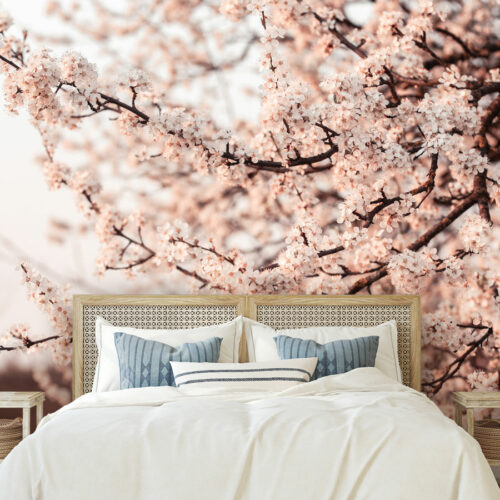 Slaapkamer met fotobehang van bloeiende kersenbloesem, gecombineerd met een naturel rotan hoofdbord en rustgevende pastelaccenten.